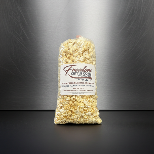 Bag of Freedom Kettle Corn with scattered popcorn on a dark background